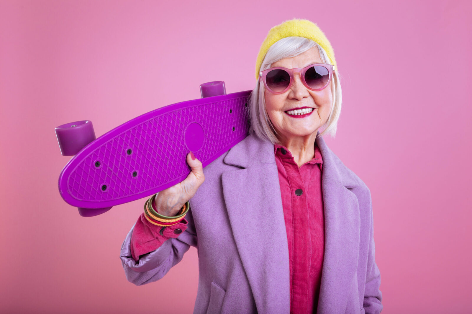 Elderly Lady Wearing Pink Sunglasses Holding Purple Skateboard